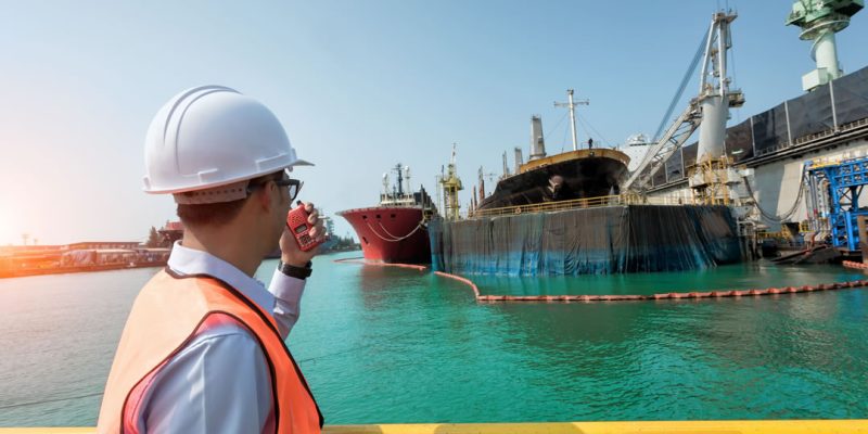 vista-trasera-de-un-hombre-trabajando-en-el-puerto-frente-al-mar